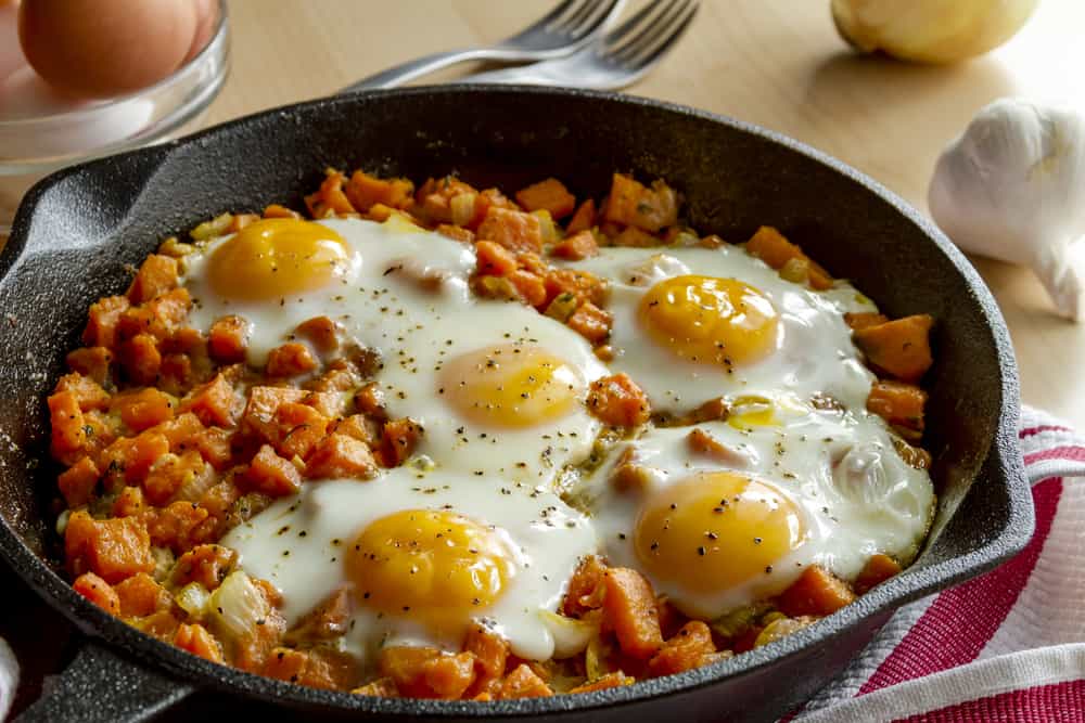 Camping cast iron skillet recipes with 5 eggs and hashbrowns in a skillet