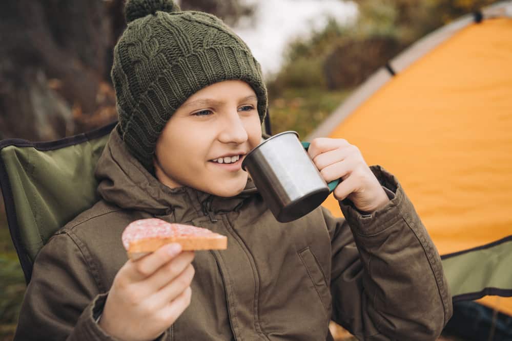 camping kid with mug and sandwich