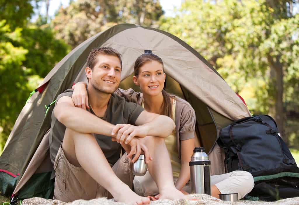 man and woman sitting outside a tent