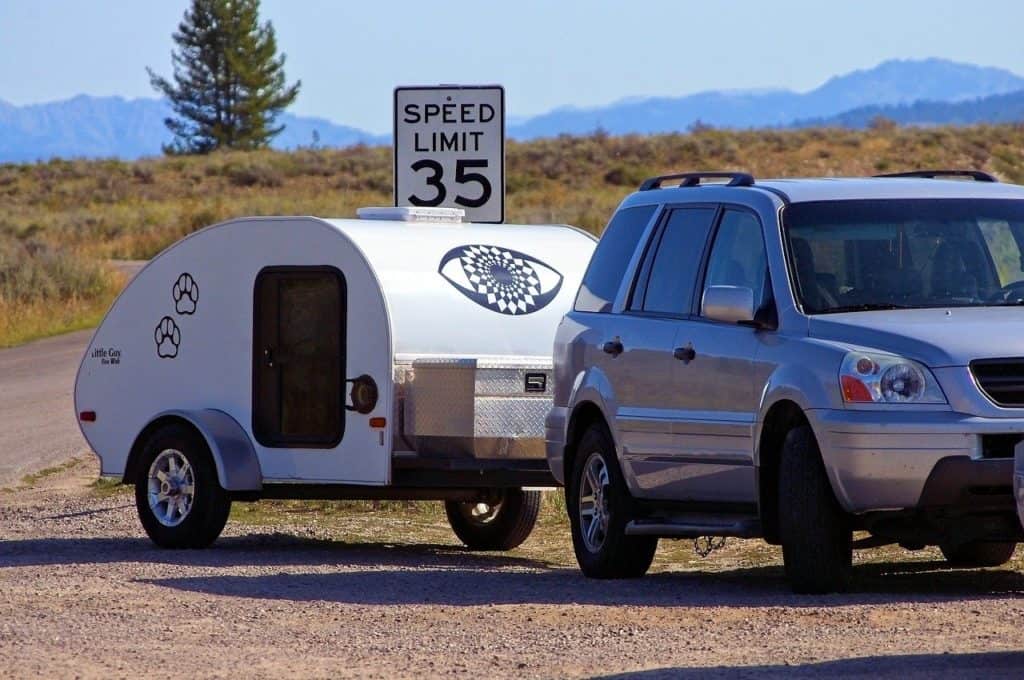a car towing a tiny camper behind