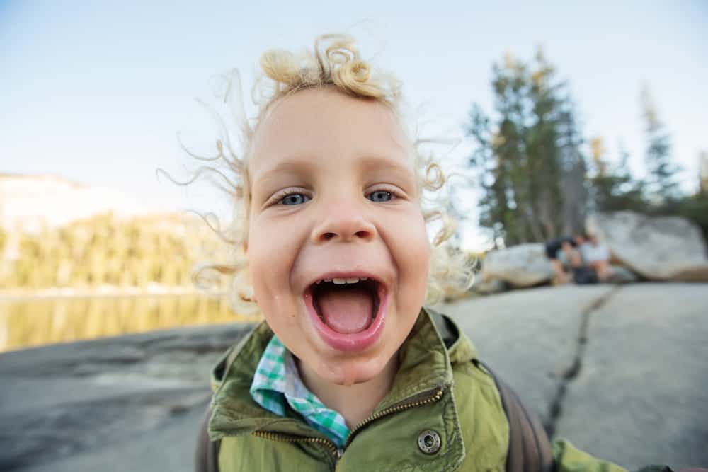 little boy with big smile outdoors