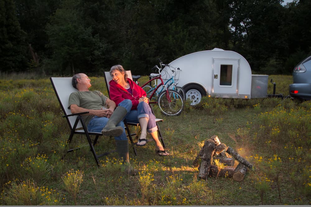 couple sitting outside teardrop camper
