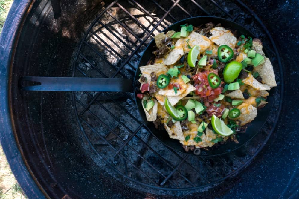 cast iron pan of nachos on a grill