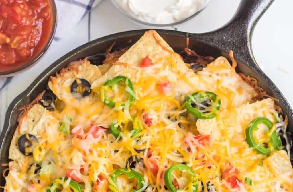 campfire nachos in cast pan with jalapenos