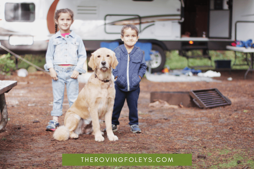 two kids and dog at campsite