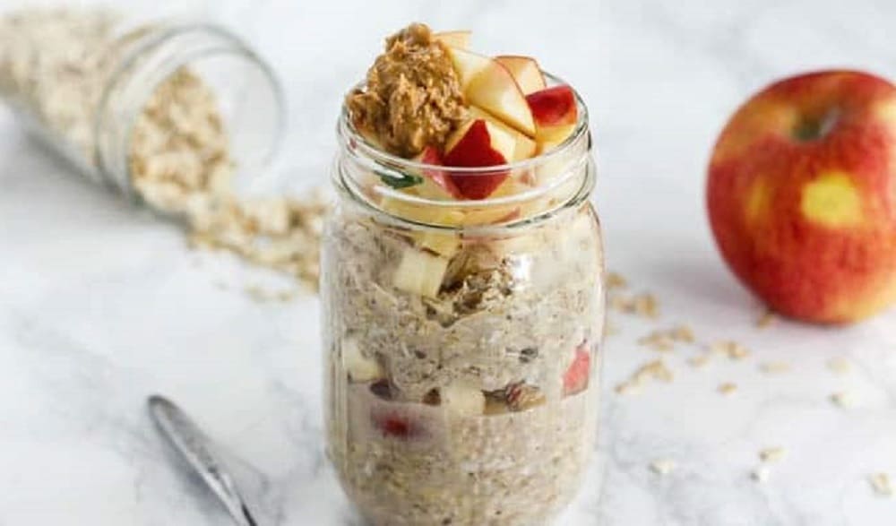 vegetarian breakfast of overnight apple cinnamon oats in a mason jar with an apple in the background