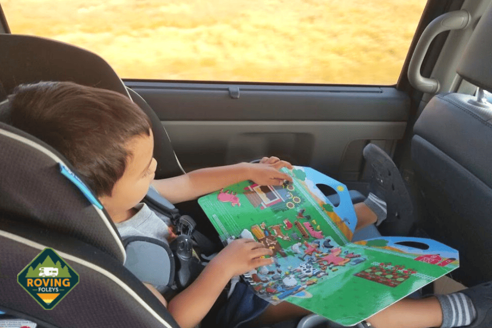 boy in car with activity book