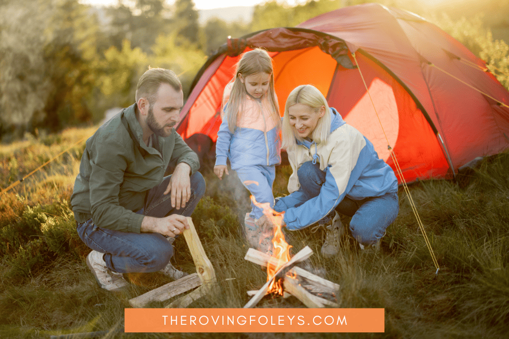 parents and little girl with tent and campfire