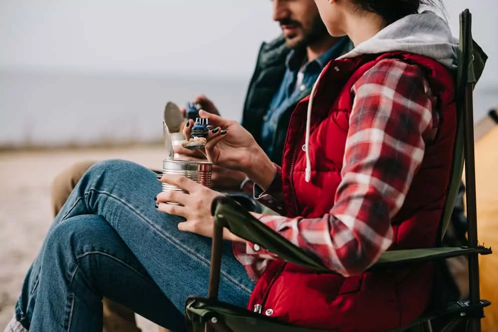 Couple at campground eating out of cans